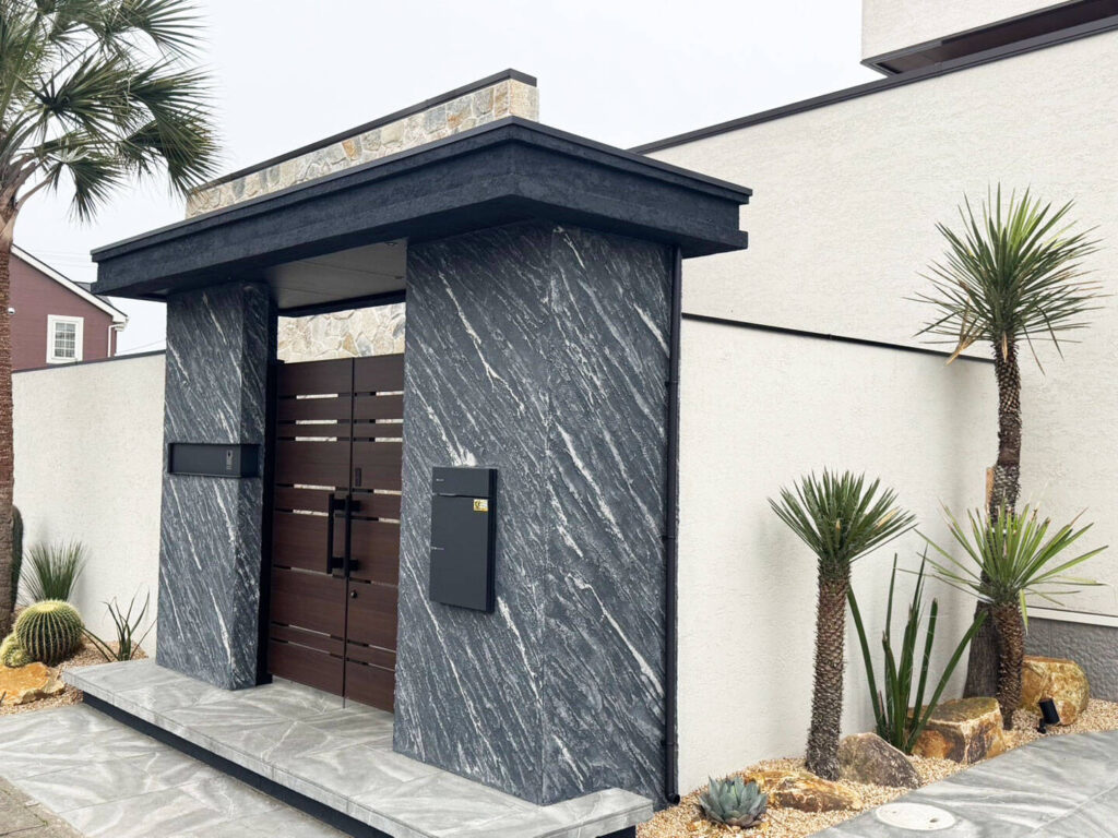 ブラック×ブラウンの天然石調風門柱とロックガーデン