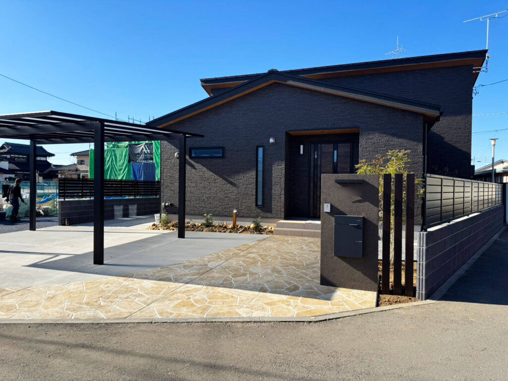 モダンで落ち着いた建物と温かみのある乱形石アプローチが調和する外構デザイン