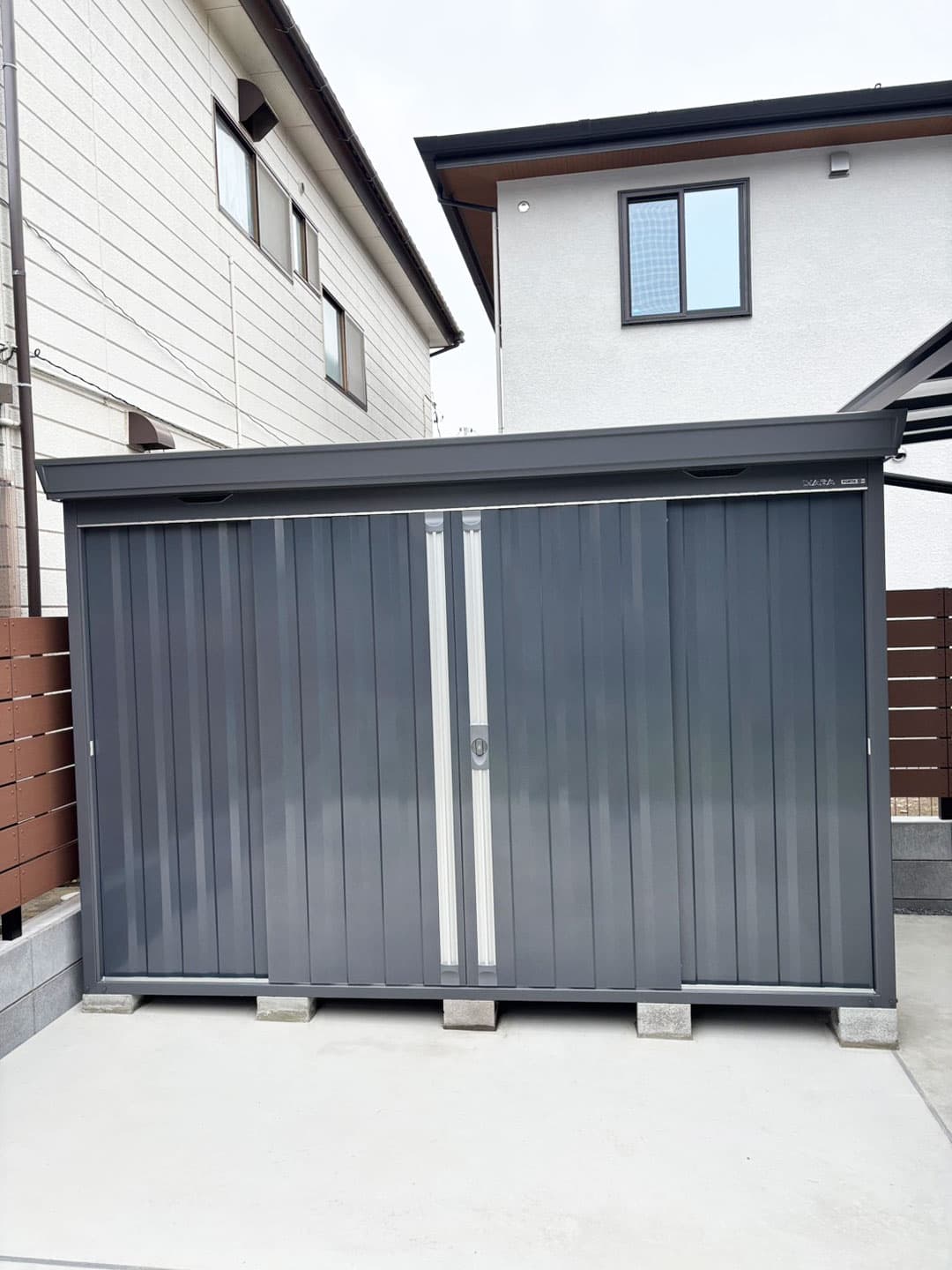 庭の一角にシンプルなネイビーの物置